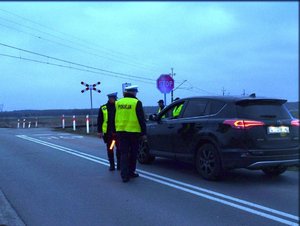 Na zdjęciu umundurowani policjanci ruchu drogowego dokonują kontroli na przejeździe kolejowym w gminie Nowa Dęba w powiecie tarnobrzeskim.