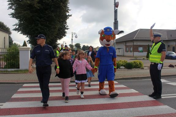 W początkowym okresie nauki dzieci i młodzieży, tarnobrzescy policjanci prowadzą działania pn. „Bezpieczna droga do szkoły”. Funkcjonariusze odwiedzają szkoły i przedszkola, aby uczyć najmłodszych prawidłowych nawyków komunikacyjnych oraz uświadamiać o potencjalnych zagrożeniach, jakie mogą ich spotkać podczas drogi do i ze szkoły.  
 Mundurowi  uczą pierwszoklasistów prawidłowego przekraczania jezdni, poruszania się po niej w przypadku braku chodnika lub pobocza, zachowania w miejscach oczekiwania na przyjazd autobusów. 
Dzisiaj mundurowi odwiedzili uczniów z Zespołu Szkół im. gen.W. Sikorskiego w Woli Baranowskiej oraz z pierwszoklasistów z Zespołu Szkół i Placówek w Baranowie Sandomierskim.
 Funkcjonariusze z Zespołu ds. Profilaktyki Społecznej, Nieletnich i Patologii Komendy Miejskiej Policji w Tarnobrzegu asp.szt. Rafał Szymański i st. sierż. Ewelina Rzeszut, poprowadzili zajęcie teoretyczne, podczas których przekazywali dzieciom wiedzę dotyczącą prawidłowego korzystania z dróg. 
Szkole spotkania z policjantem są dla dzieci zawsze dużą atrakcją, co zachęca je do poznawania zasad ruchu drogowego. Nie do przecenienia jest wiedza funkcjonariuszy ruchu drogowego. Asp. Eligiusz Skuza z Wydziału Ruchu Drogowego z Komendy Miejskiej Policji w Tarnobrzegu uczył dzieci właściwego zachowania się na przejściach dla pieszych, wskazał im też najbardziej niebezpieczne miejsca w rejonie szkoły. Policjant drogówki zaprezentował ręczne kierowanie ruchem na drodze co dla pierwszoklasistów było nie lada atrakcją i z pewnością niezapomnianą lekcją.
Przedstawiciele Wojewódzkiego Ośrodka Ruchu Drogowego propagowali wśród uczniów noszenie elementów odblaskowych. Przekazali dla każdego ucznia opaski odblaskowe, plany lekcji i materiały edukacyjne.

 
Przypominamy - zgodnie z art. 43 Ustawy prawo o ruchu drogowym, dziecko do 7 roku życia może korzystać z drogi tylko pod opieką osoby co najmniej 10-letniej (nie dotyczy to strefy zamieszkania i drogi przeznaczonej wyłącznie dla pieszych). Rodzice, którzy zawożą dzieci do szkoły powinni pamiętać o obowiązku przewożenia ich w fotelikach ochronnych lub specjalnych siedziskach. Dziecko pod szkołą należy wysadzać z samochodu od strony chodnika lub pobocza, nie zaś od strony jezdni.