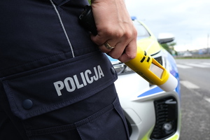 na zdjęciu widoczny funkcjonariusz Policji trzymający w ręku urządzenie do badania stanu trzeźwości