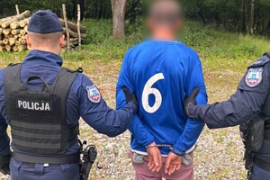 Policjanci prowadzą zatrzymanego mężczyznę